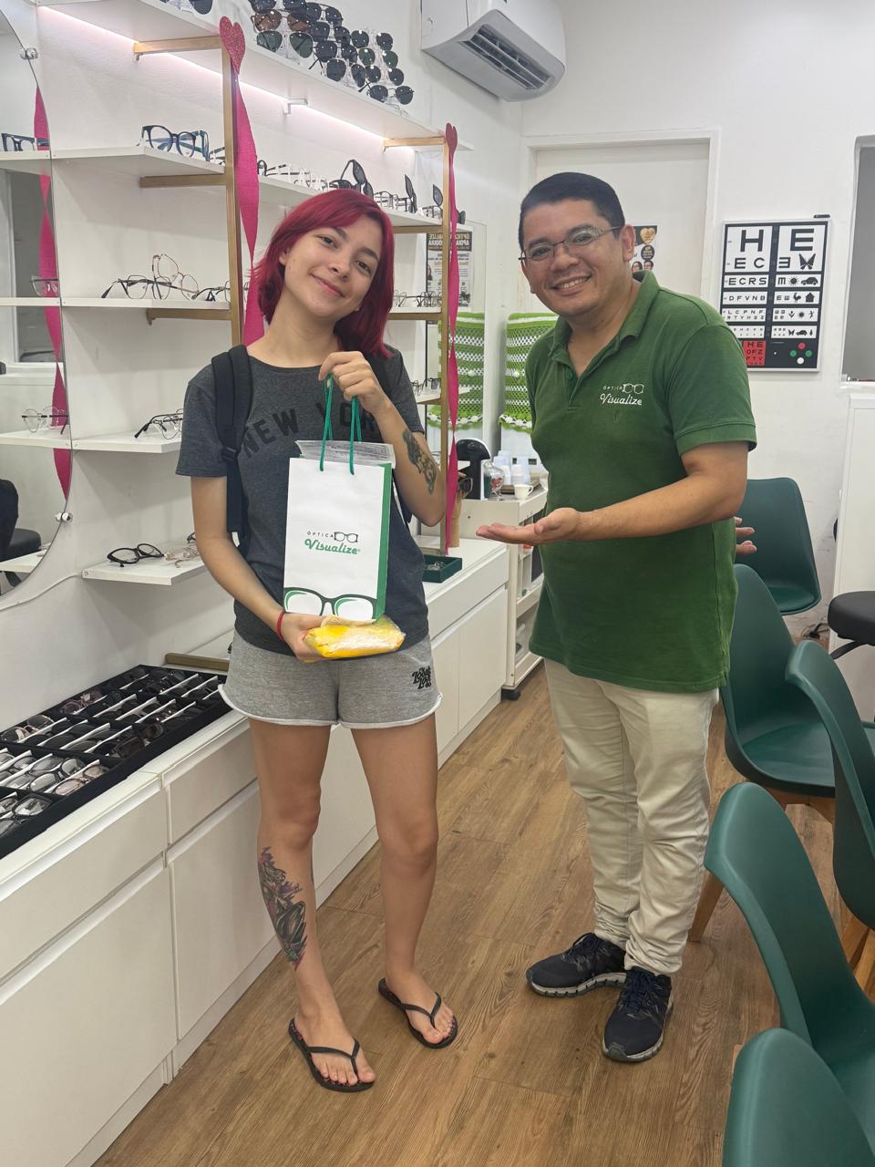 Cliente com sacola e brinde da Óptica Visualize