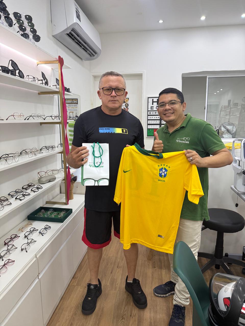Cliente recebendo camisa do Brasil como brinde