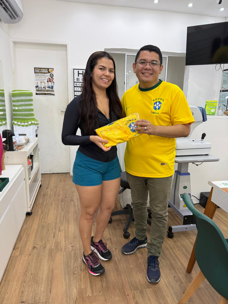 Cliente real recebendo óculos na Óptica Visualize